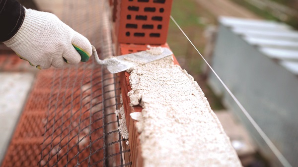 Construction Worker. Portrait Of Mason Bricklayer Installing Red