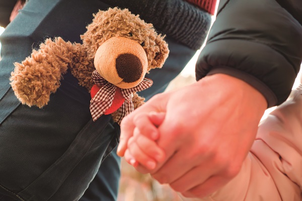 Hands Of Parent And Child Outdoor Closeup. Father Holds Hands Of