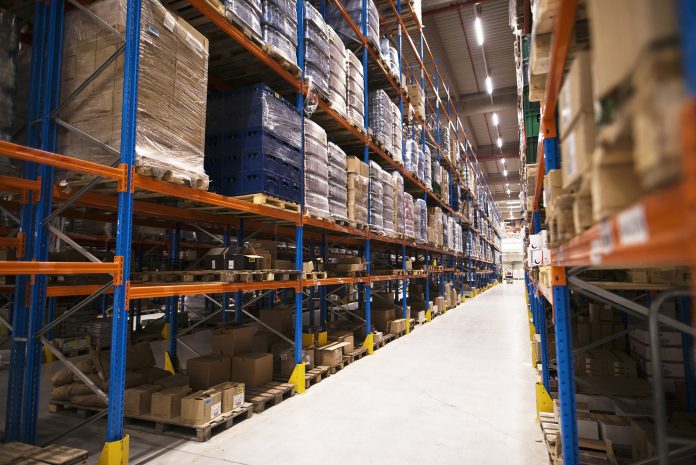 Interior of large distribution warehouse with shelves stacked wi